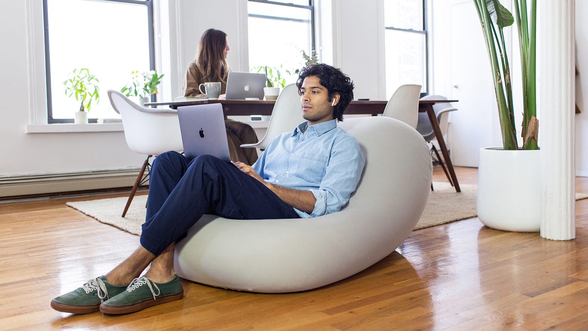 A person using a laptop in a Moon Pod bean bag chair. 