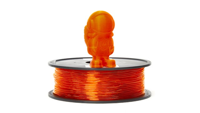 Orange roll of filament with an astronaut model on top