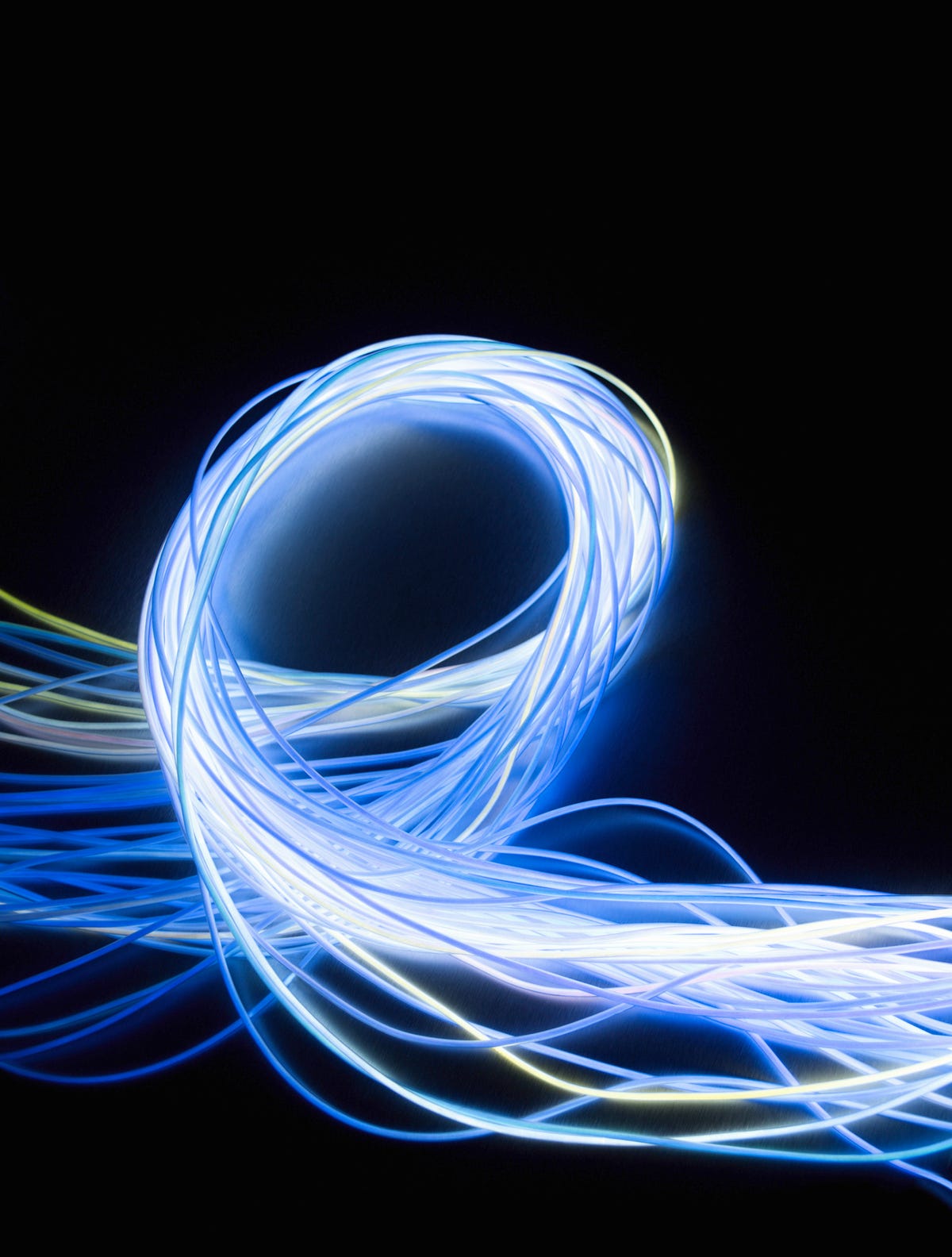 Looped bundles of fiber optic cables against a black background