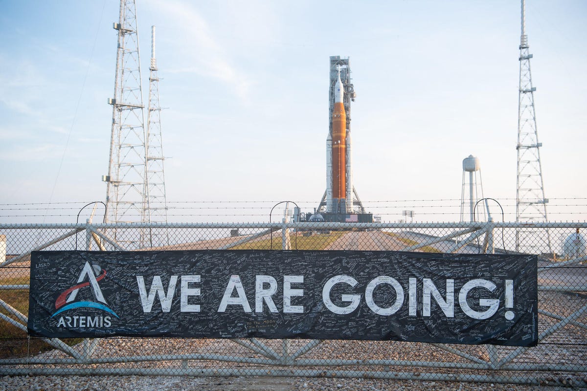 Artemis I rocket and Orion capsule on the launchpad. In the foreground, a banner says "We are going!".