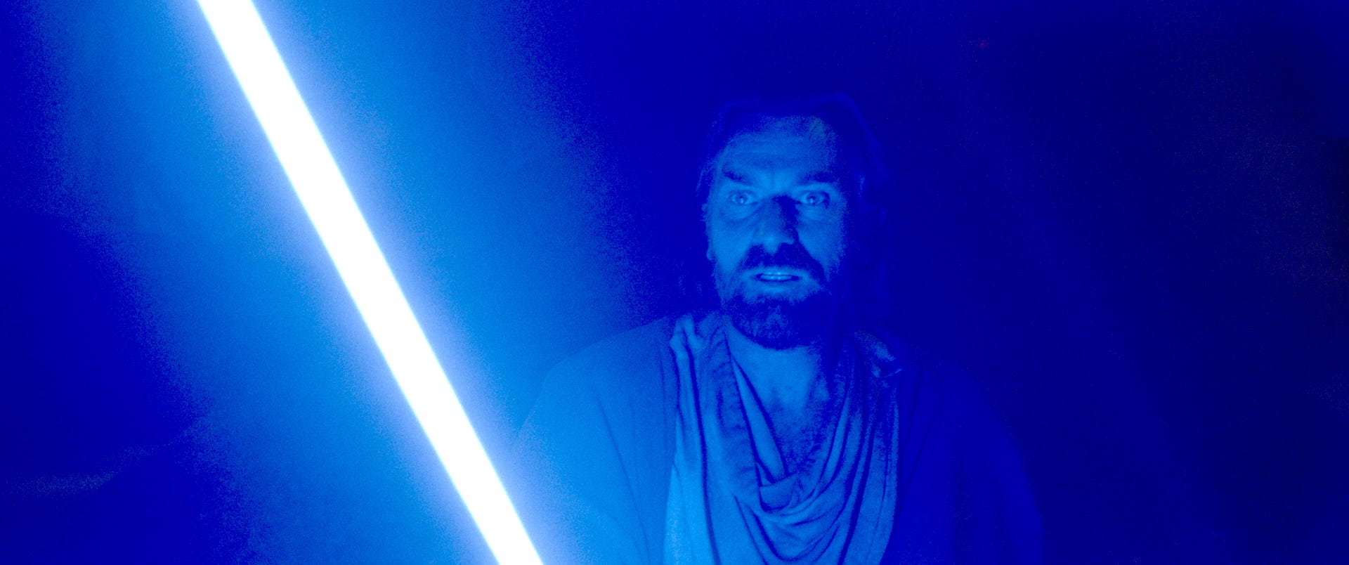 An angry alien bad guy lit by the glare of a red lightsaber in Obi-Wan Kenobi on Disney Plus.