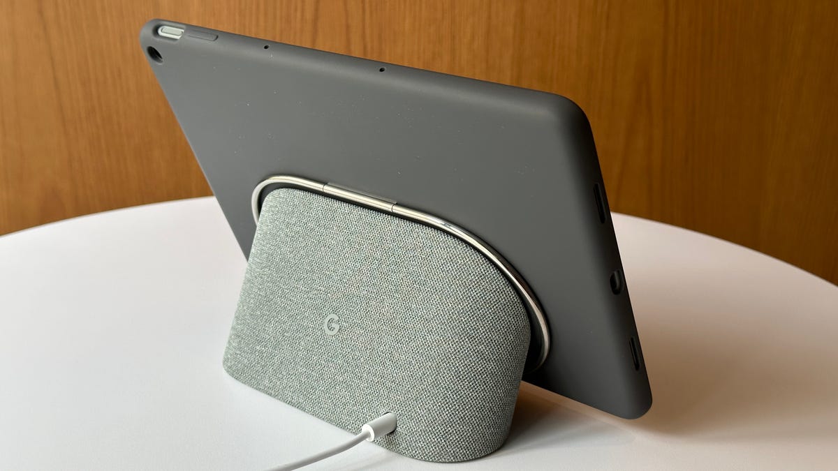 The back of a gray speaker dock with a dark gray tablet attached to it