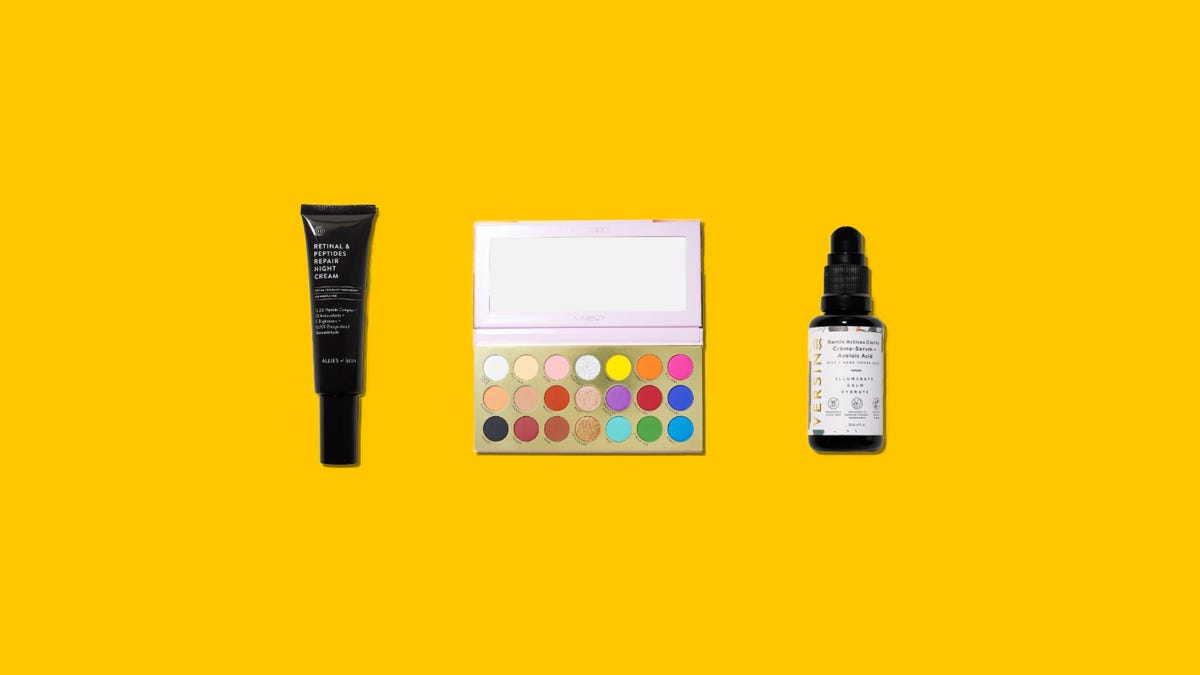 A foundation bottle, multicolored palette and serum bottle on a yellow background