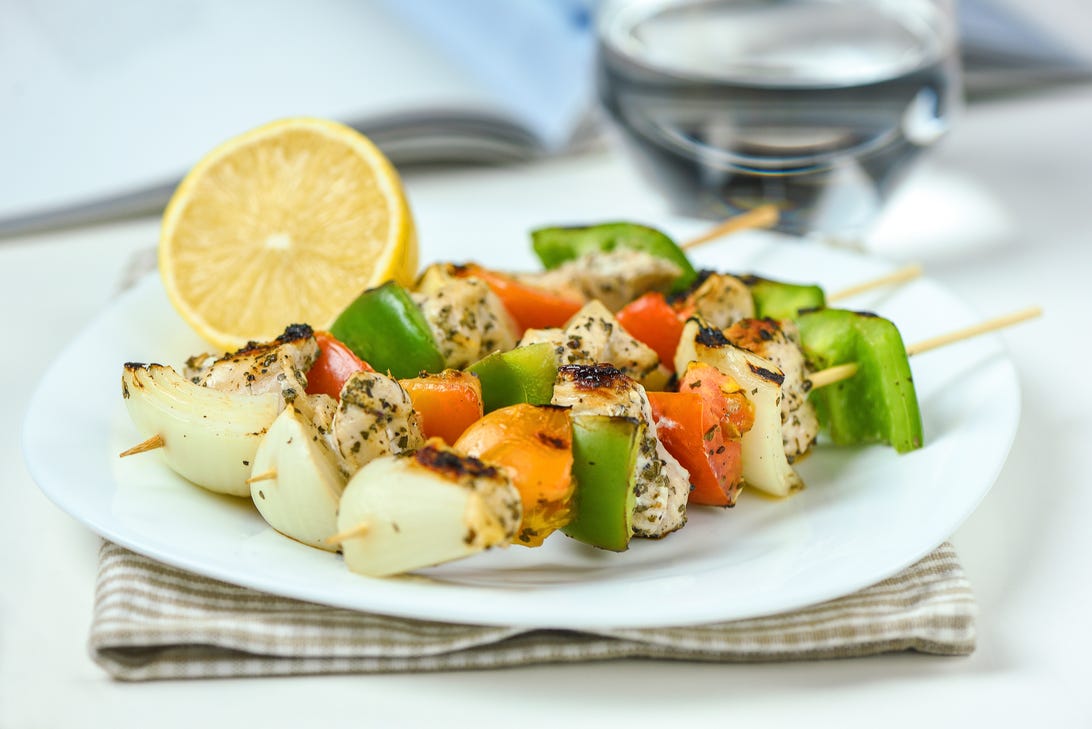 Three vegetable kebabs and lemon on a plate