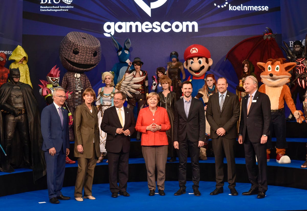 German Chancellor Angela Merkel (center, in front of various cosplay characters) opens the Gamescom conference in Cologne.