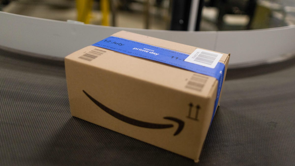 An Amazon delivery box sealed with Prime Day tape on a conveyor belt