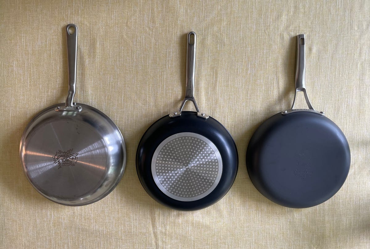 three skillets on yellow tablecloth