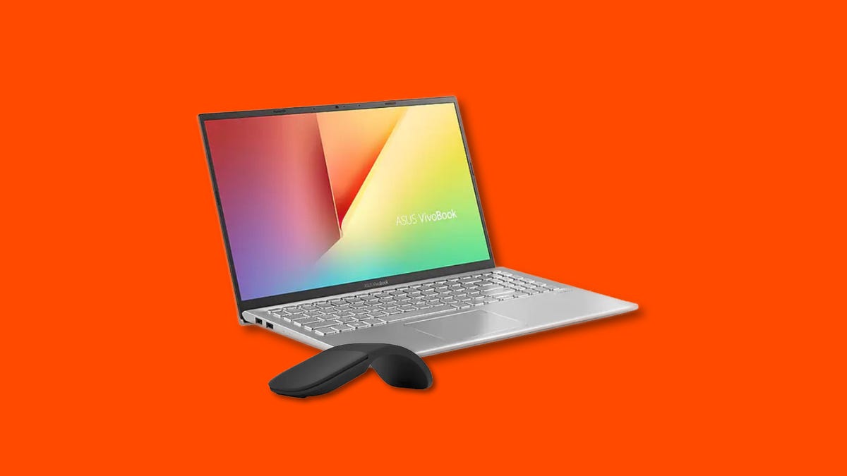 A silver Asus VivoBook and a black Microsoft Arc mouse on a orange background