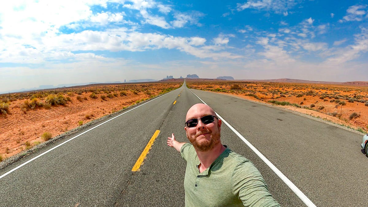 Geoffrey Morrison standing in the middle of the road in a desert.