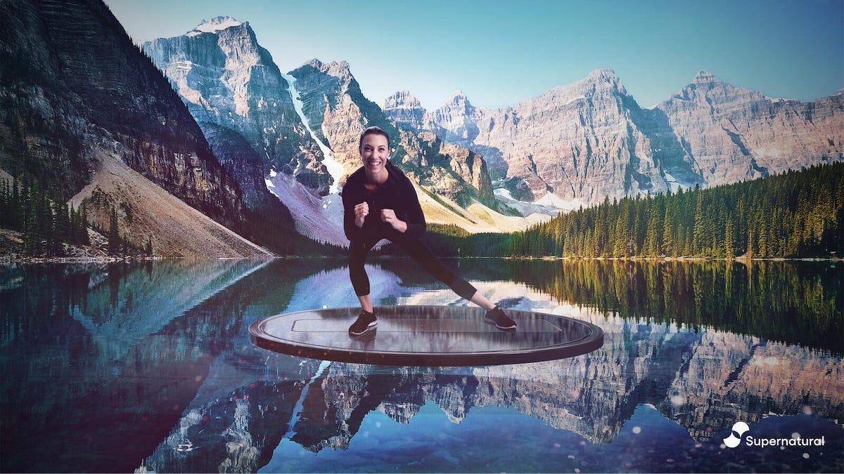 A coach lunges to her left on a circular platform seeming to float above the surface of a mountain lake in VR. 