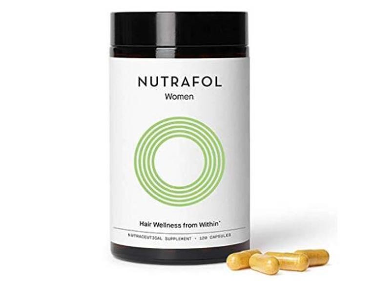Bottle of Nutrafol Women vitamins with four capsules placed in front