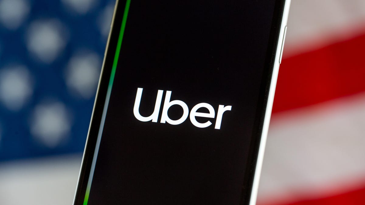 Uber logo on a phone screen, with an American flag in background