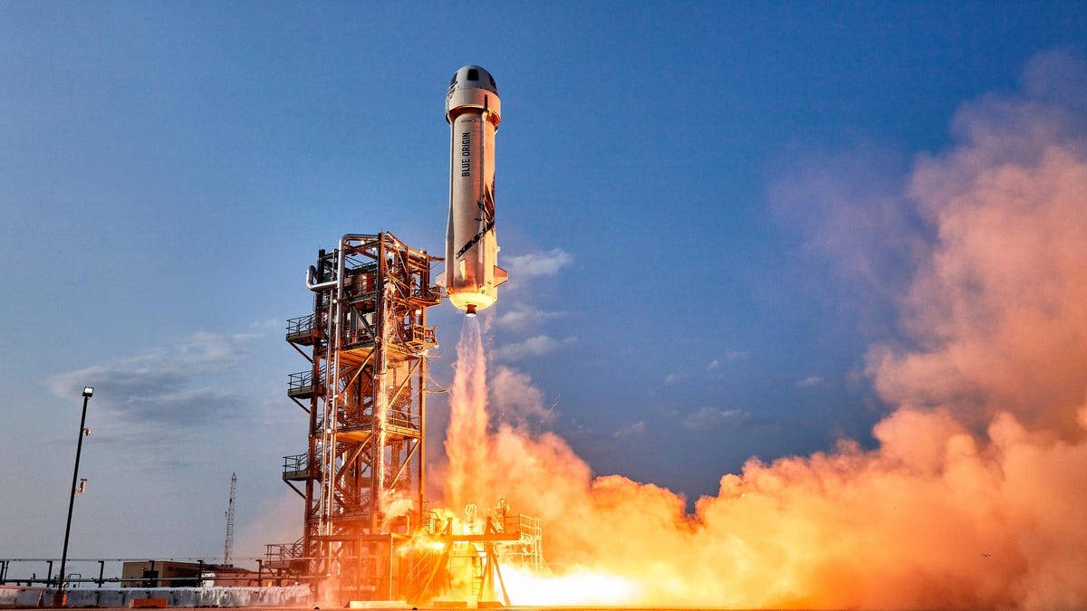 Blue Origin New Shepard rocket in flight, with a fiery exhaust
