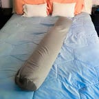 Frida Mom Adjustable Keep-Cool Pregnancy Pillow on bed