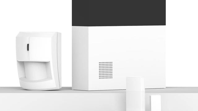 Abode devices like the hub, motion detector, and key fob stand on white shelves against a white background.