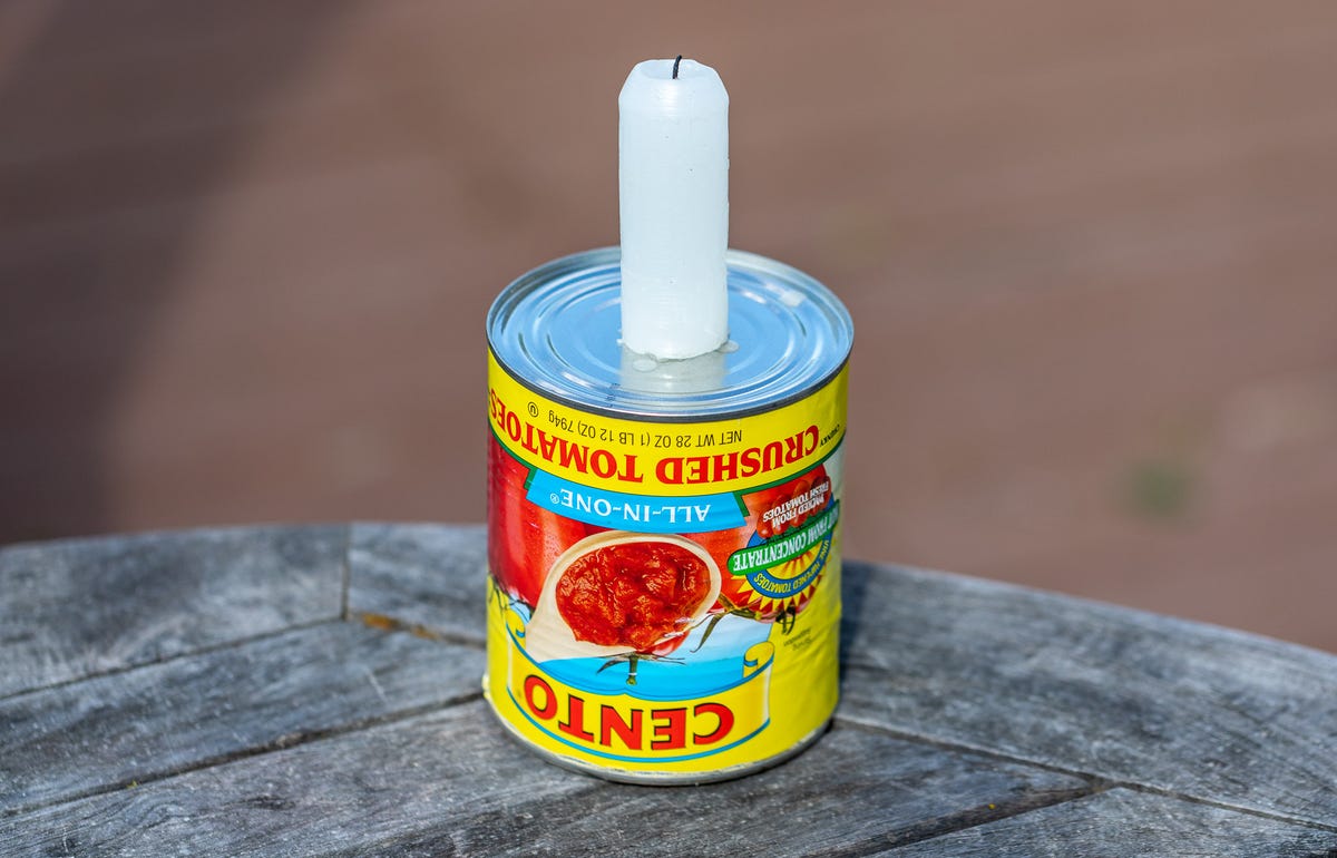 a candle on top of a can of tomatoes