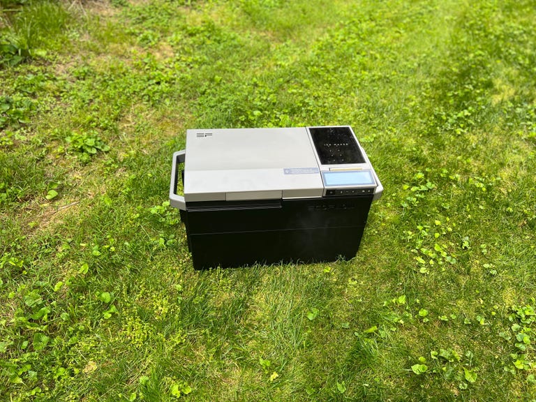 The EcoFlow Glacier electric cooler sits in some grass with its lid closed.