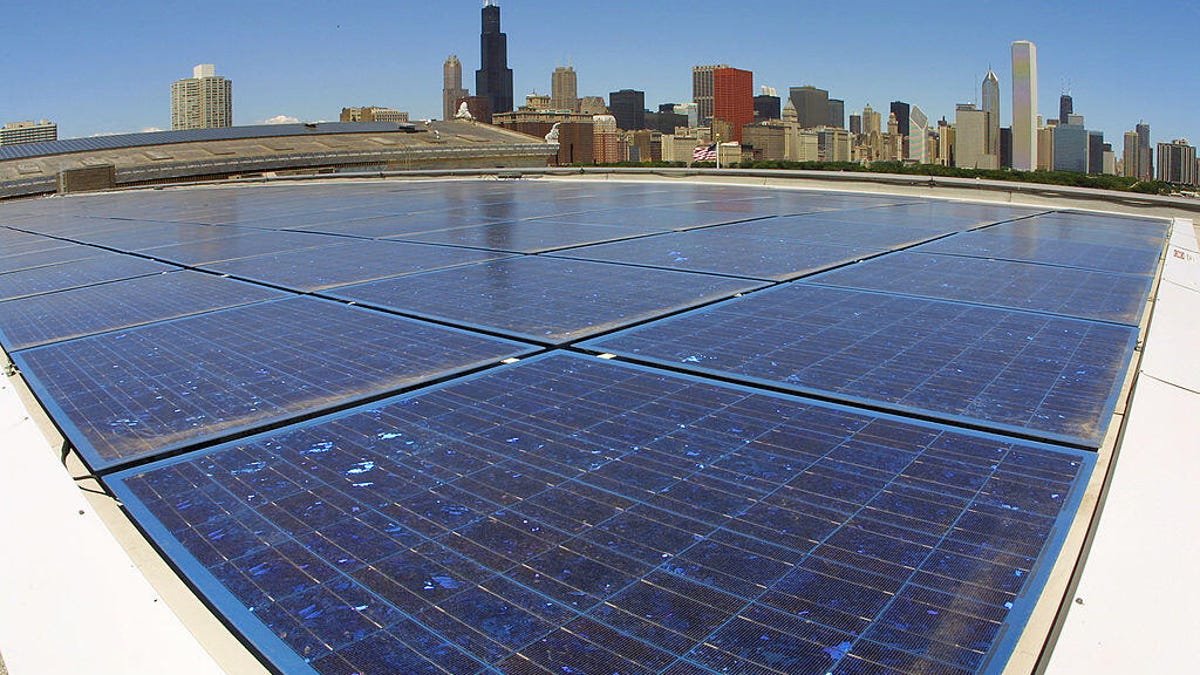 The Chicago skyline is seen in the background, with solar panels on top of of the Field Museum of Natural History in the foreground.