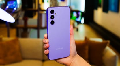 Samsung's Galaxy A54 5G in purple being held up