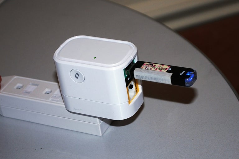 The DIR-505 was demoed at CES 2012, hosting a thumbdrive for data sharing. Note the Wi-Fi Protected Setup button on its side.