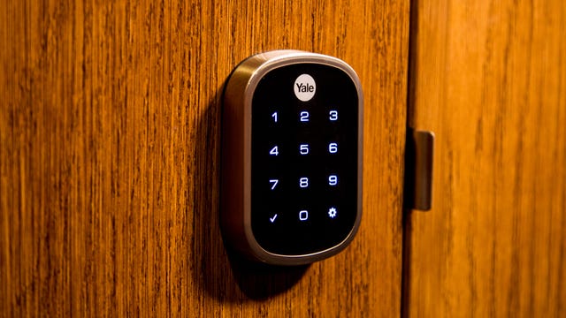 The Yale Assure Lock SL Key Free Touchscreen Deadbolt installed on a maple wood door.