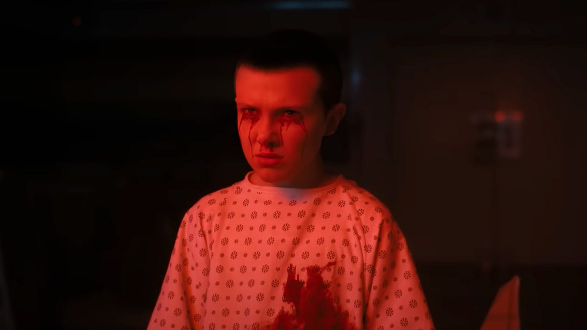 A young Eleven in a hospital gown, looking worried