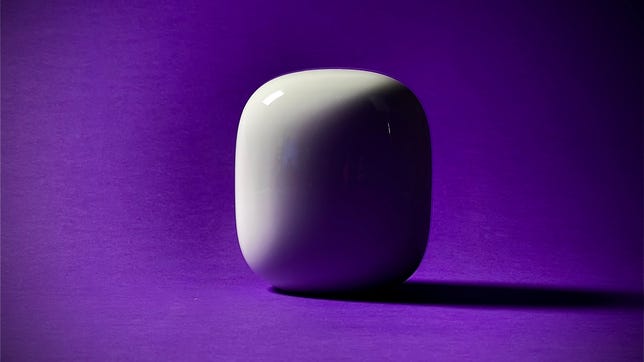 A single Nest Wifi Pro mesh router device sitting against a purple background, with a dramatic shadow cast to the side.