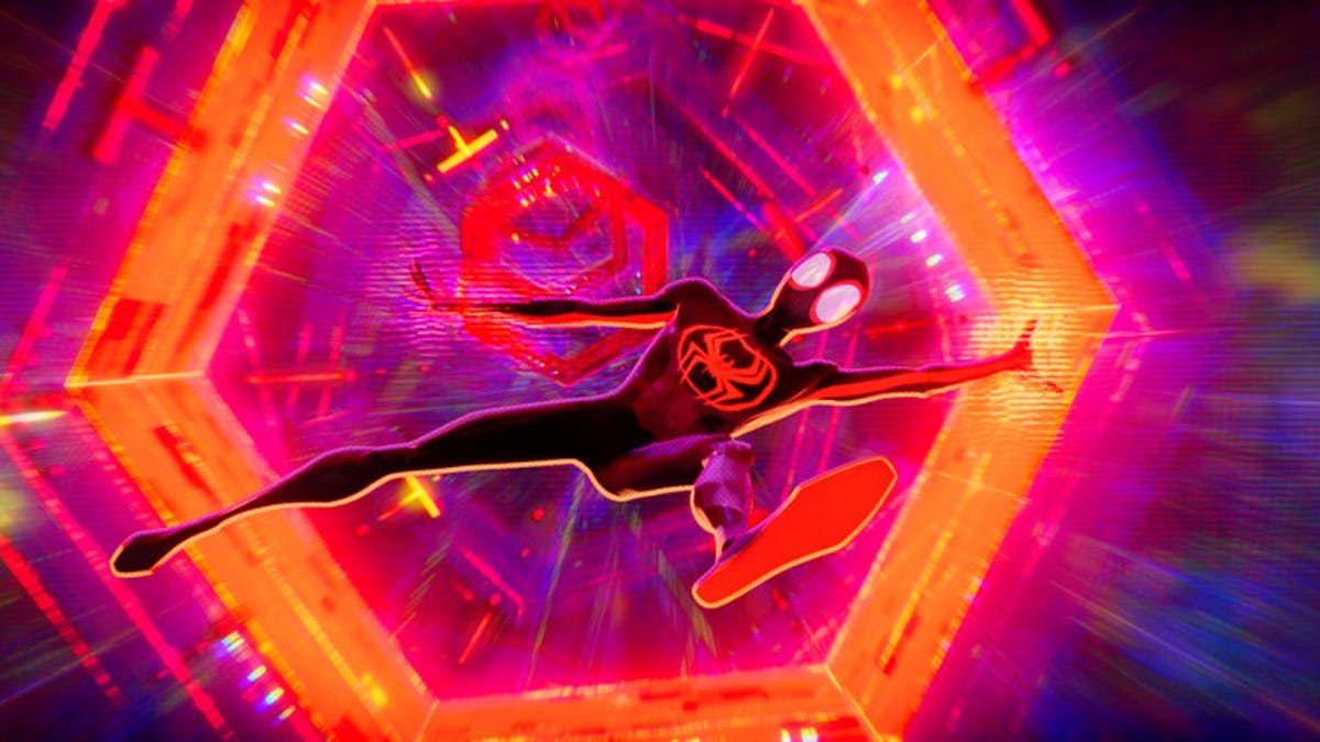 A costumed Miles Morales falls through an orange interdimensional portal in Spider-Man: Across the Spider-Verse, against a mostly purple background