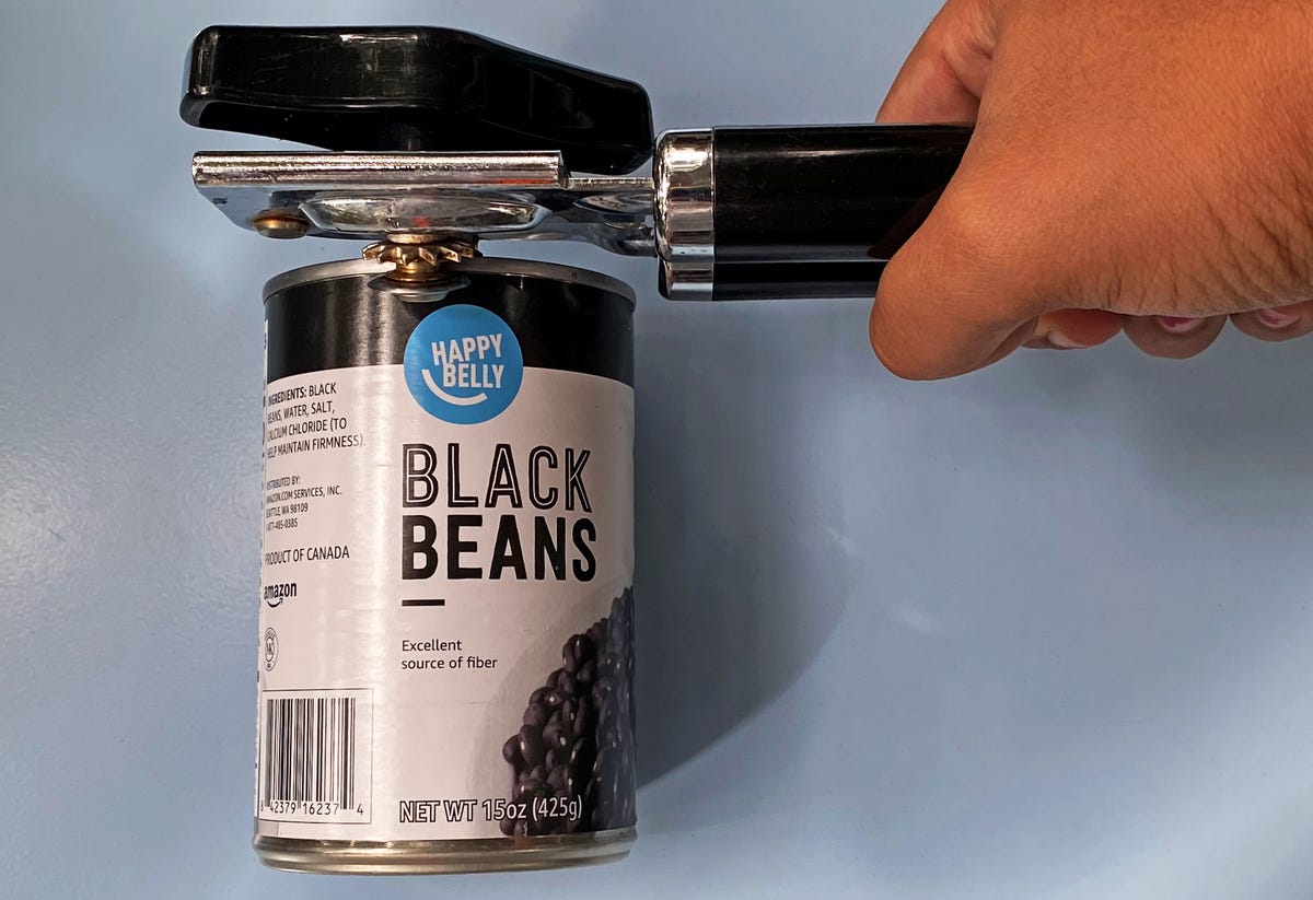 A can opener opening a can of black beans.