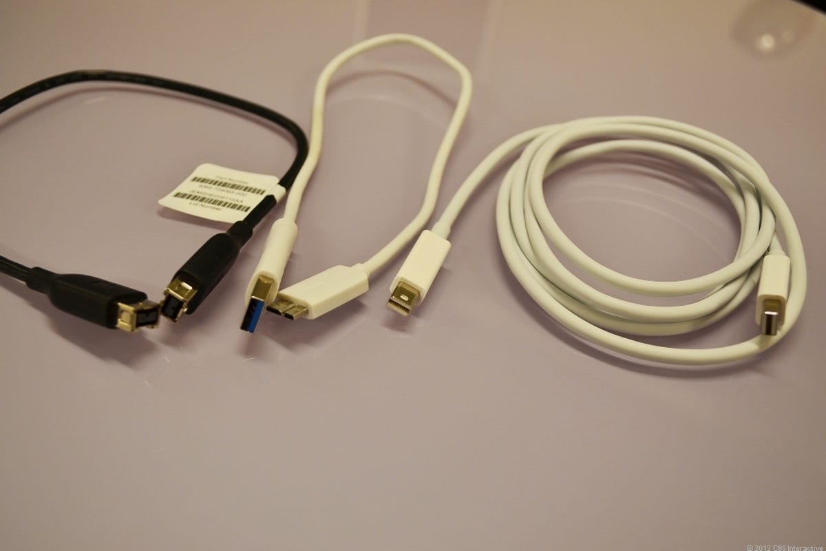 A FireWire 800 cable (left) next to a Thunderbolt cable.
