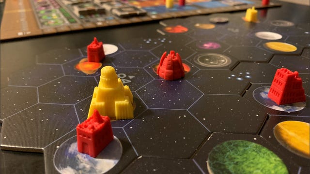 red and yellow pieces on a tiled board with space and planets