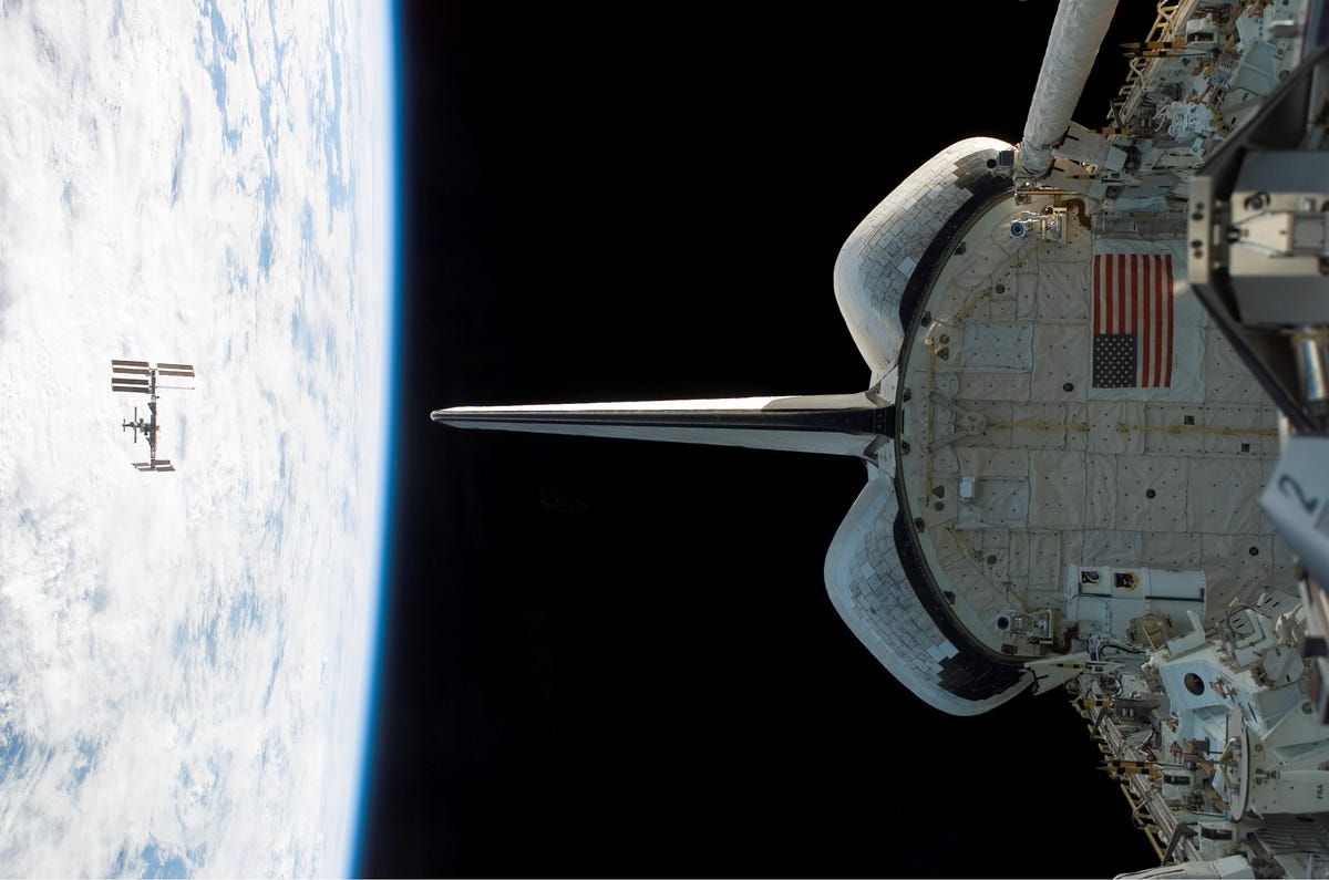 NASA's Space Shuttle Endeavour orbits near the International Space Station in 2008. The ISS orbits somewhat higher than 200 miles above the Earth's surface, roughly the distance from New York to Boston.