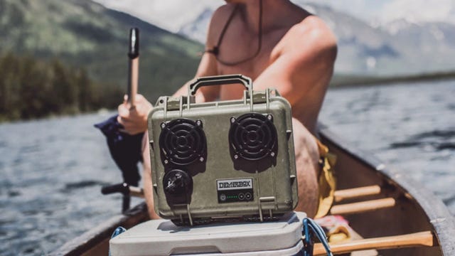 green bluetooth speaker in a canoe on a river