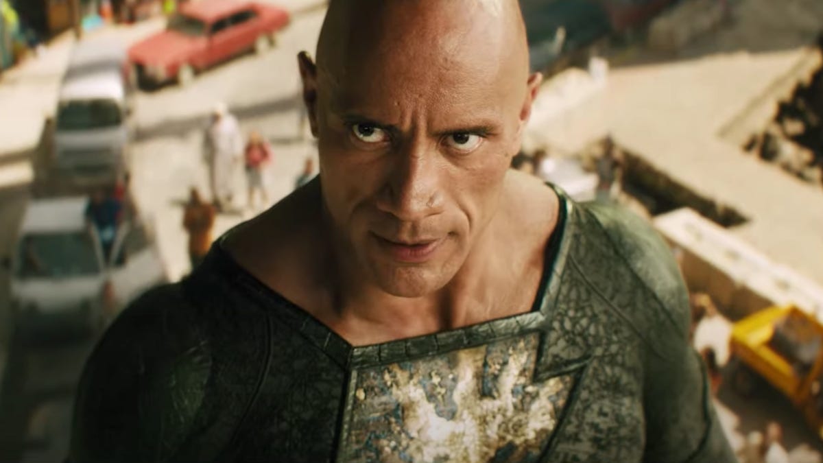Close up of Dwayne Johnson as Black Adam flying above a busy street