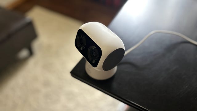 A Eufy S350 camera perchs at the corner of a black desk.