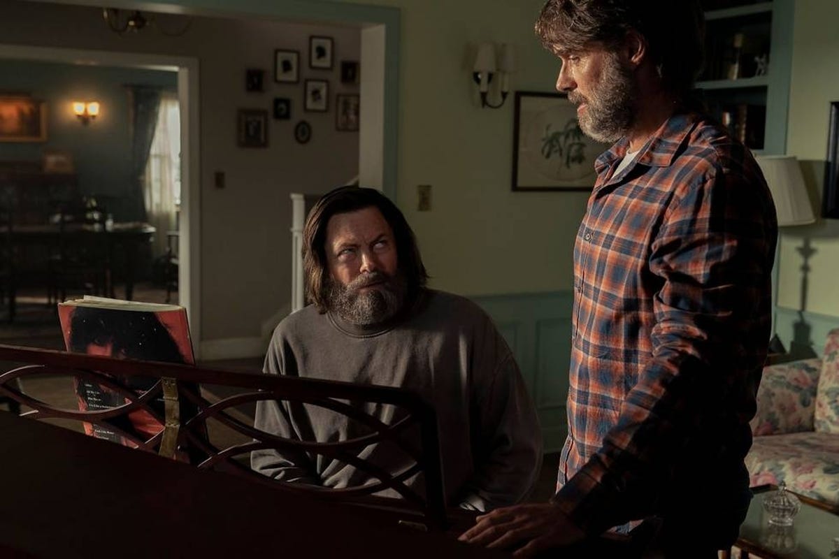 Nick Offerman's Bill sits at a piano and looks up sheepishly at Murray Bartlett's Frank in The Last of Us episode 4