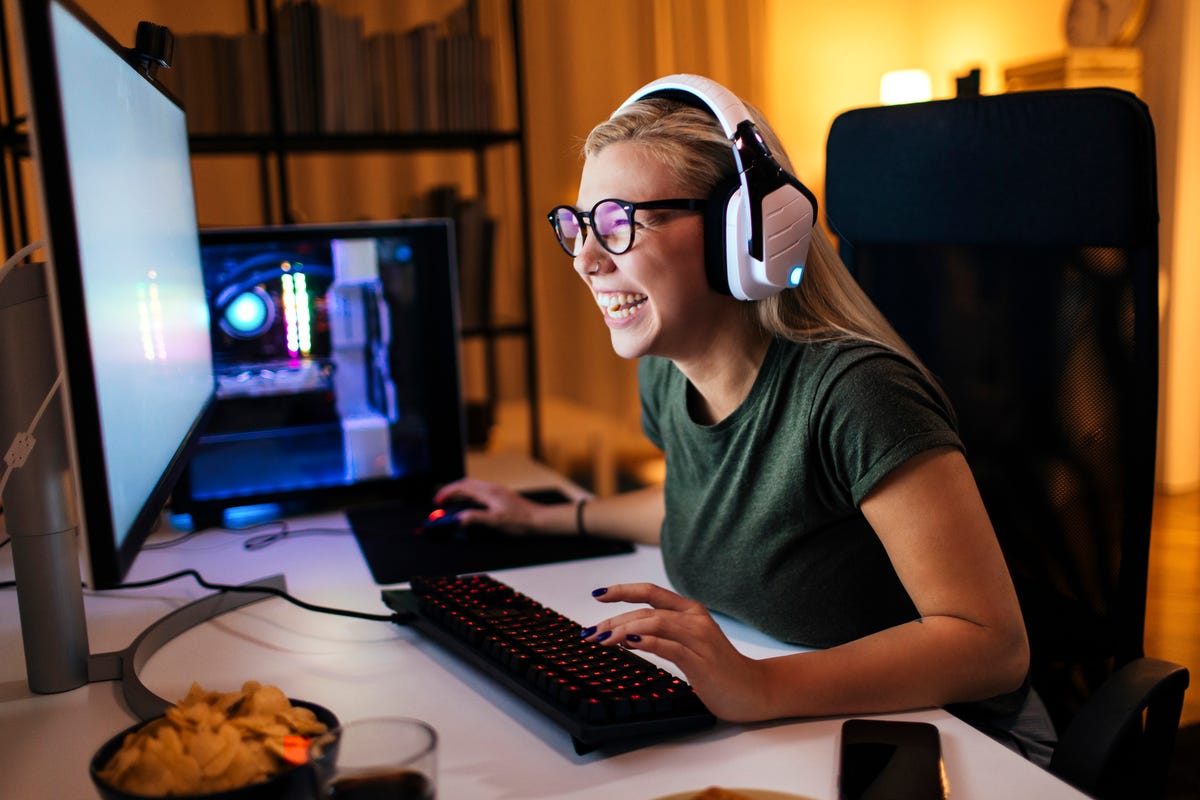 Mujer jugando videojuegos en una computadora de escritorio