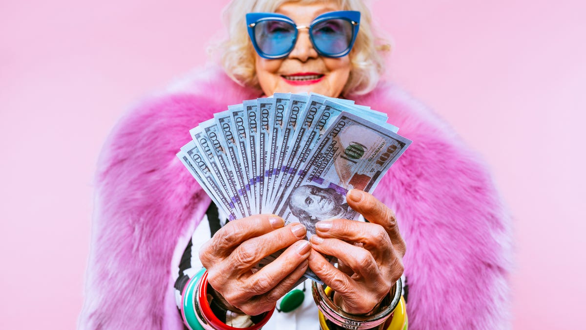 Glamorous older woman holding cash