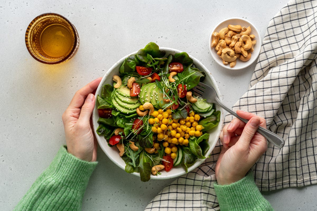 vegan plant-based salad in bowl with avocado, cashews and more
