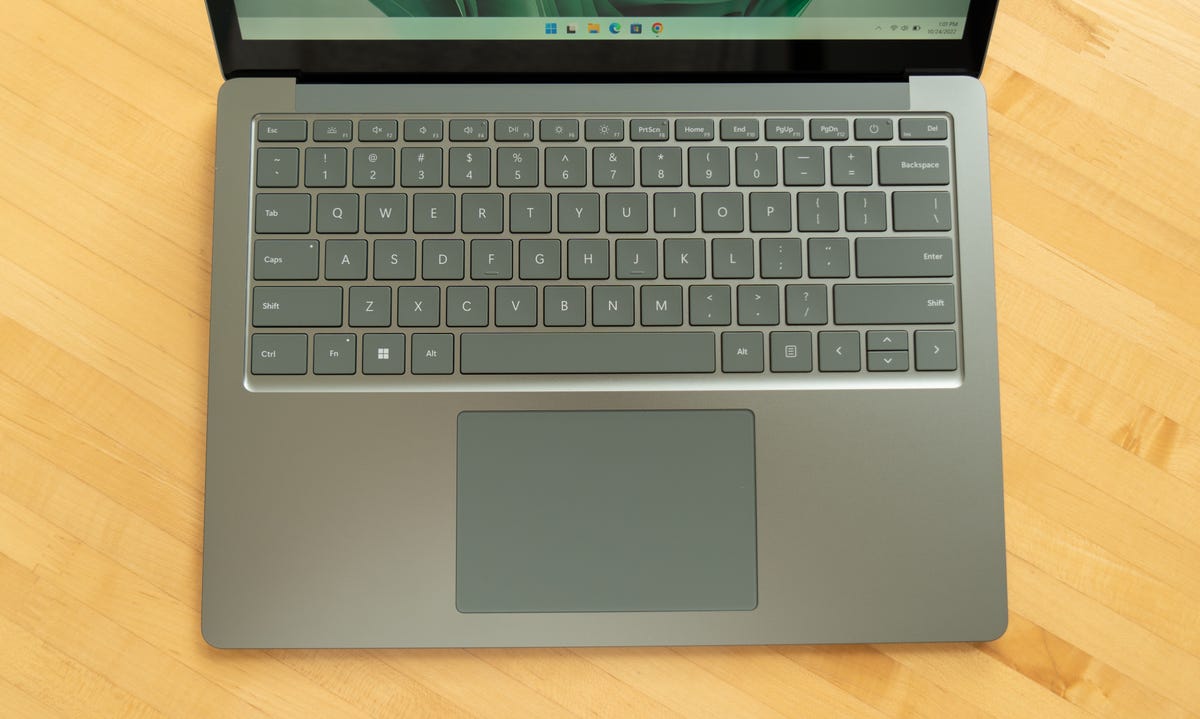 Top down view of the keyboard and touchpad, attempting to show the green of the laptop