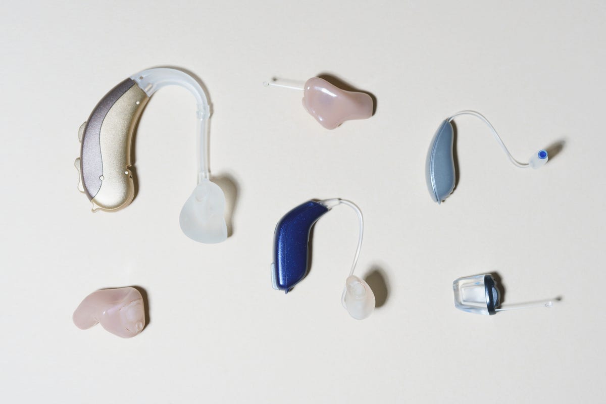 Various hearing aids arranged on a surface.