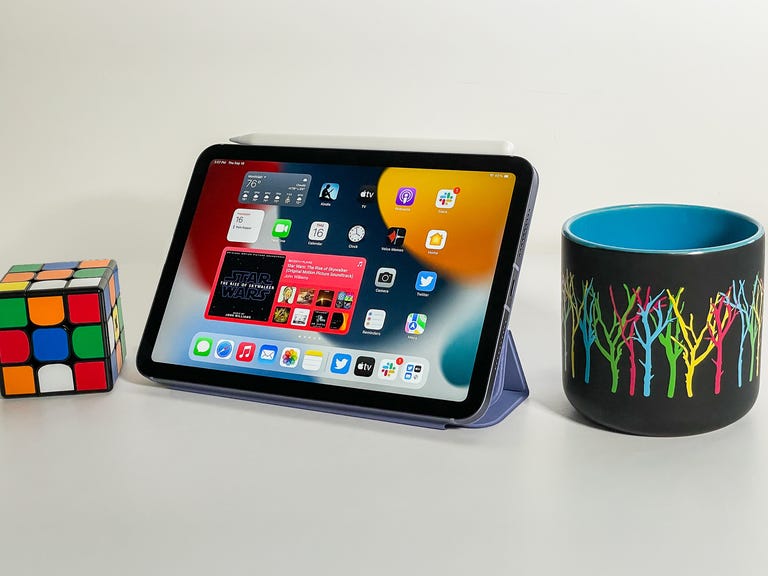 The new iPad Mini sits between a Rubik's cube and a mug for size comparison.