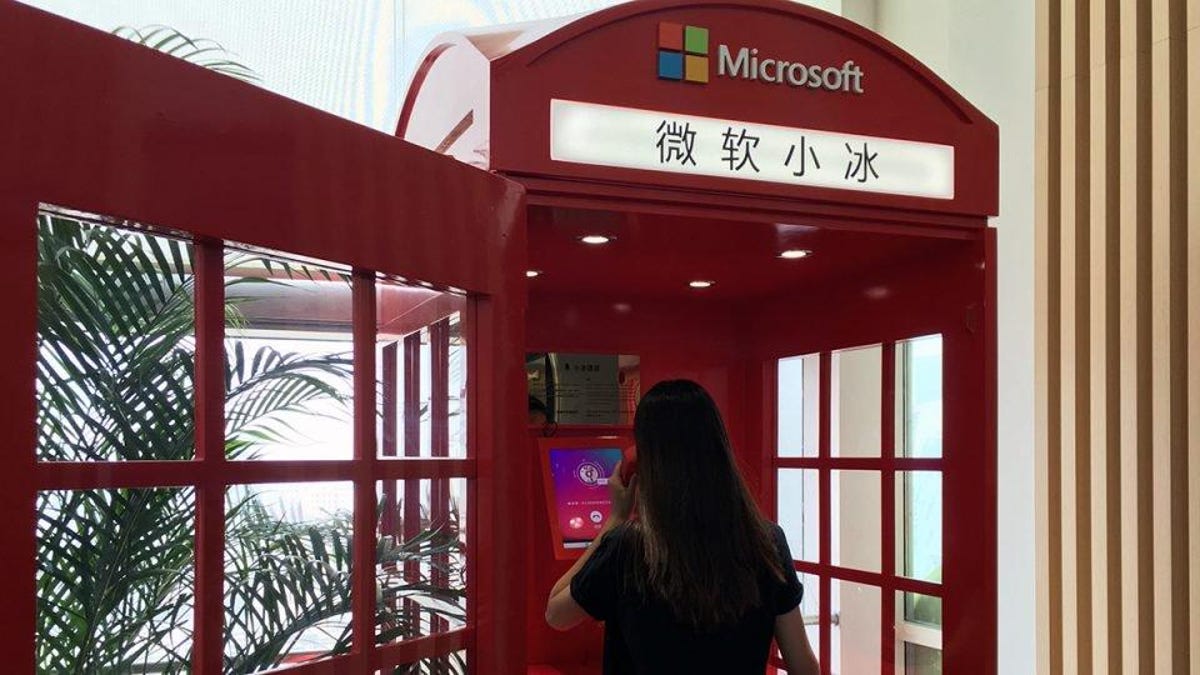 A woman makes a call in a Microsoft-branded phone booth.