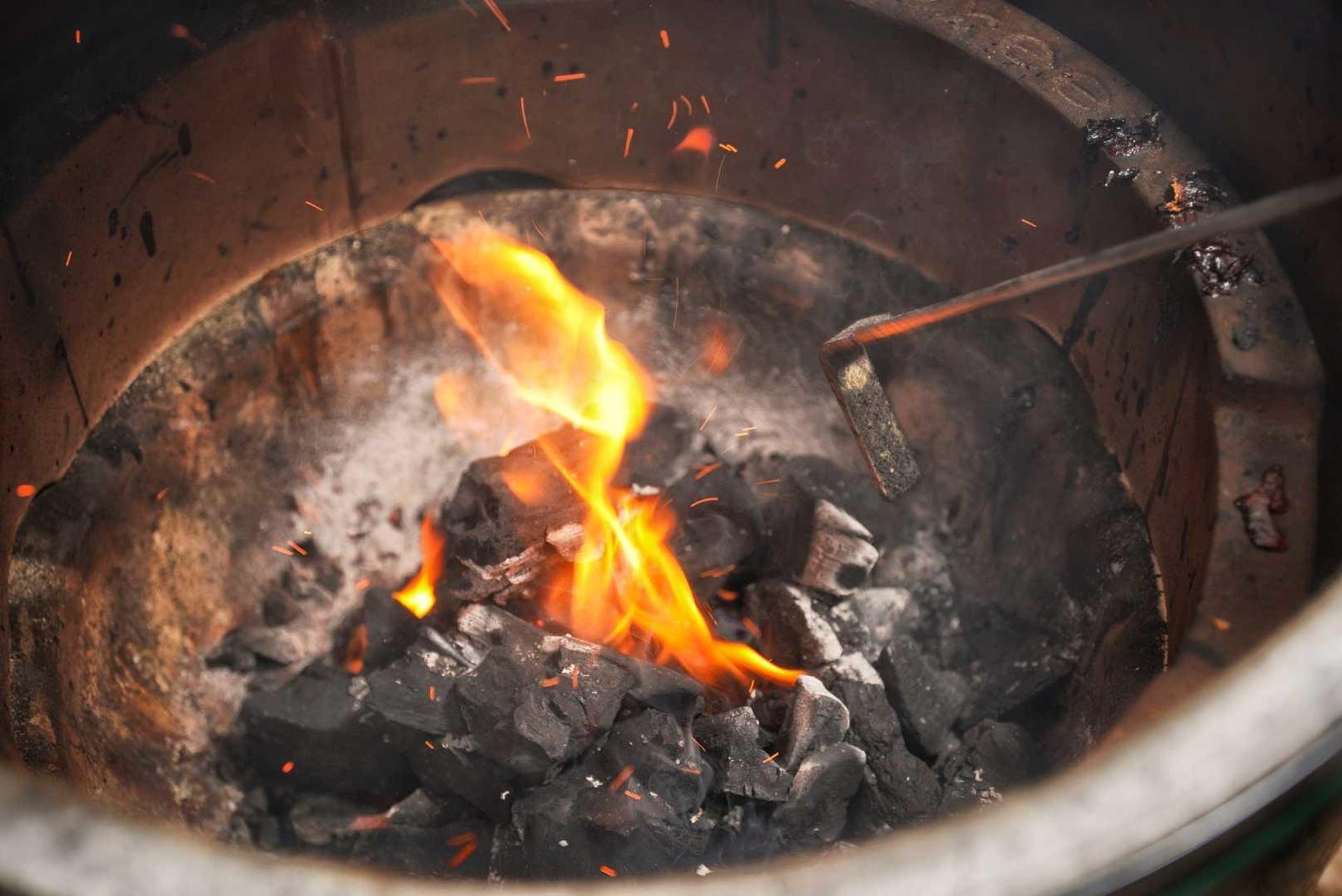 Charcoal being ignited in a grill. 