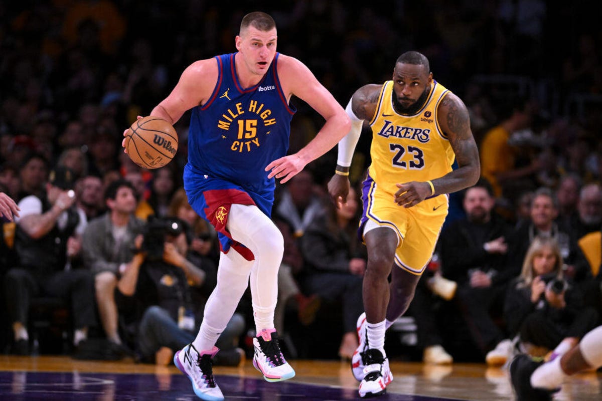 Nuggets Nikola Jokic, #15, drives downcourt followed by Lakers LeBron James, #23, during second quarter action in game 3 of the first-round playoff series