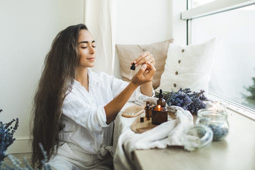 Woman dropping lavender essential oils on her wrists