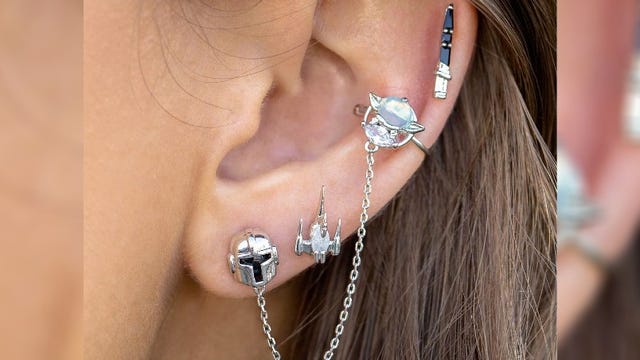 An ear with Star Wars earrings attached