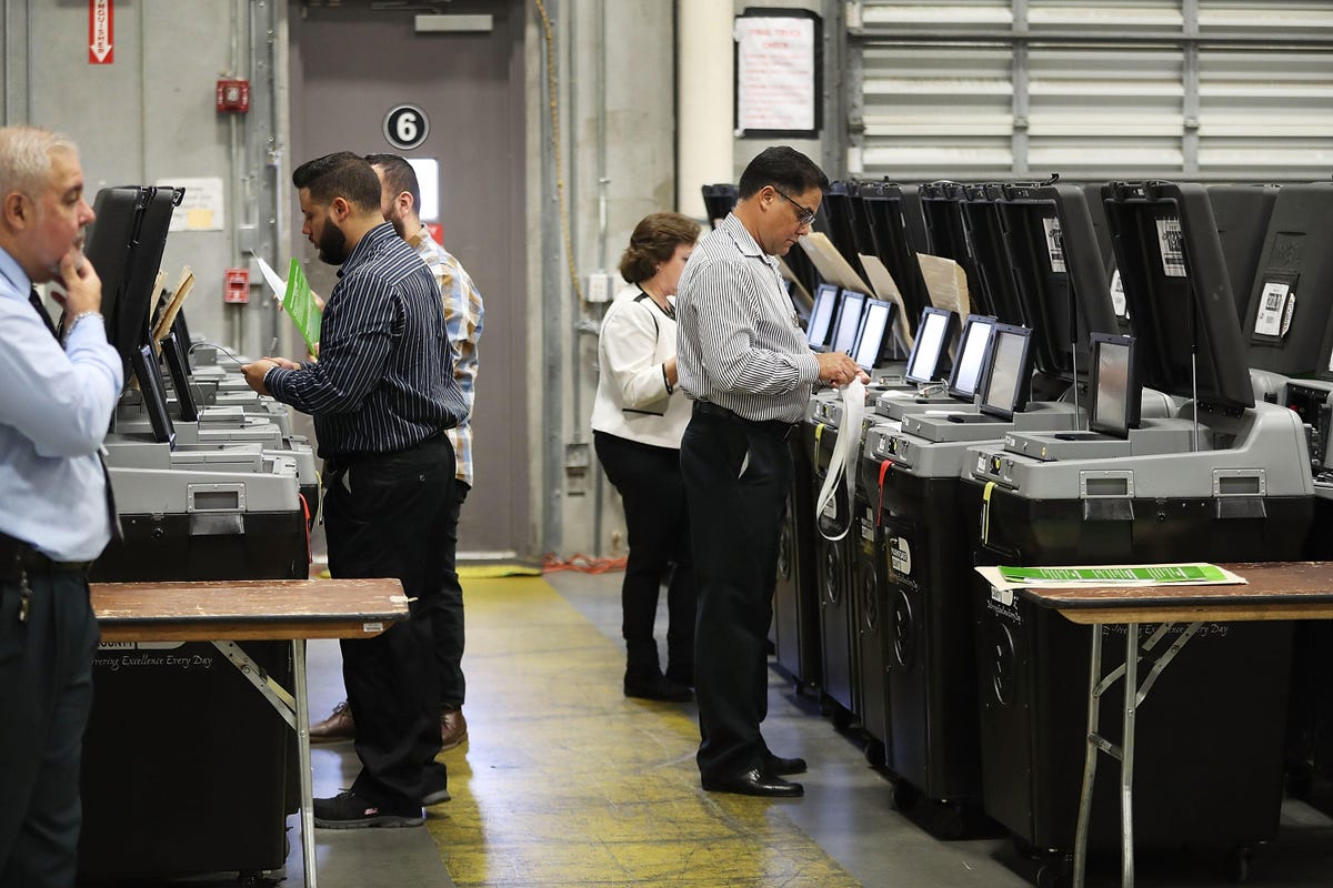 County election support specialists check voting machines for accuracy at the Miami-Dade Election Department headquarters on August 8 in Doral, Florida.