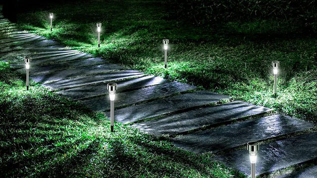 Outdoor solar lights light up a walking path in the yard at night.