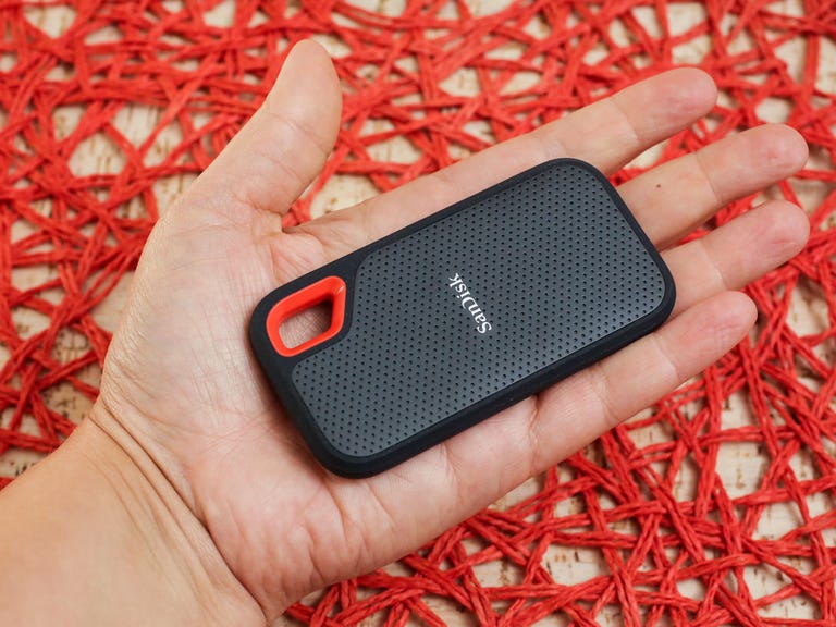 A hand holds the pocket-sized SanDisk Extreme portable 2TB SSD.